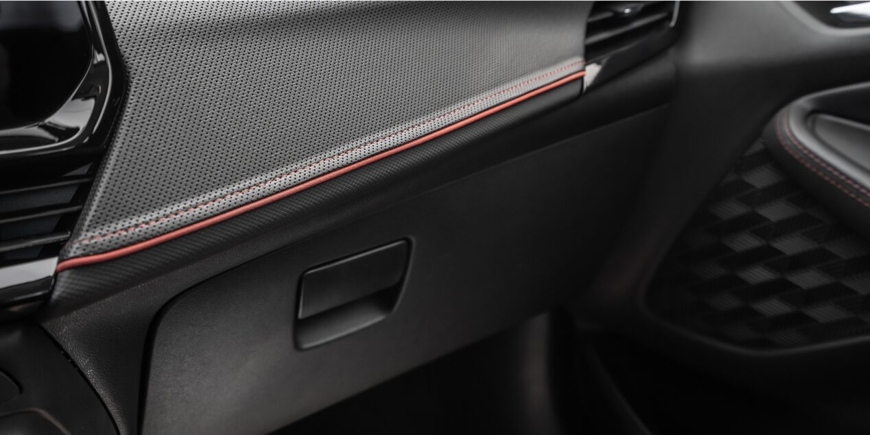 Vista en detalle de la guantera en color Jet Black con detalles en rojo y negro High Gloss.