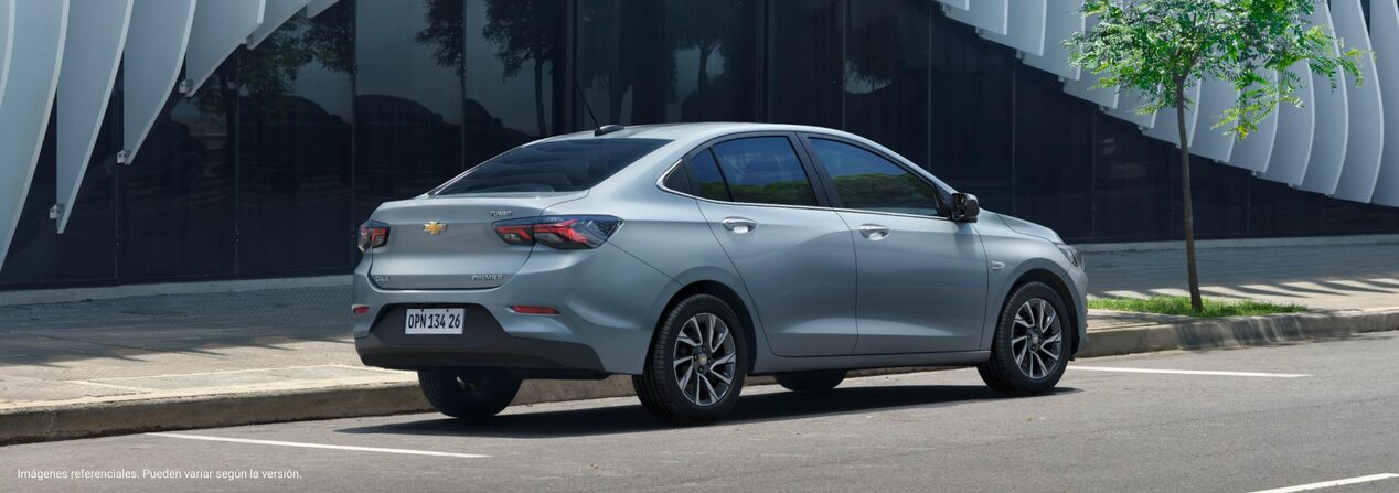 Vista trasera del Onix Plus estacionado frente a un edificio.