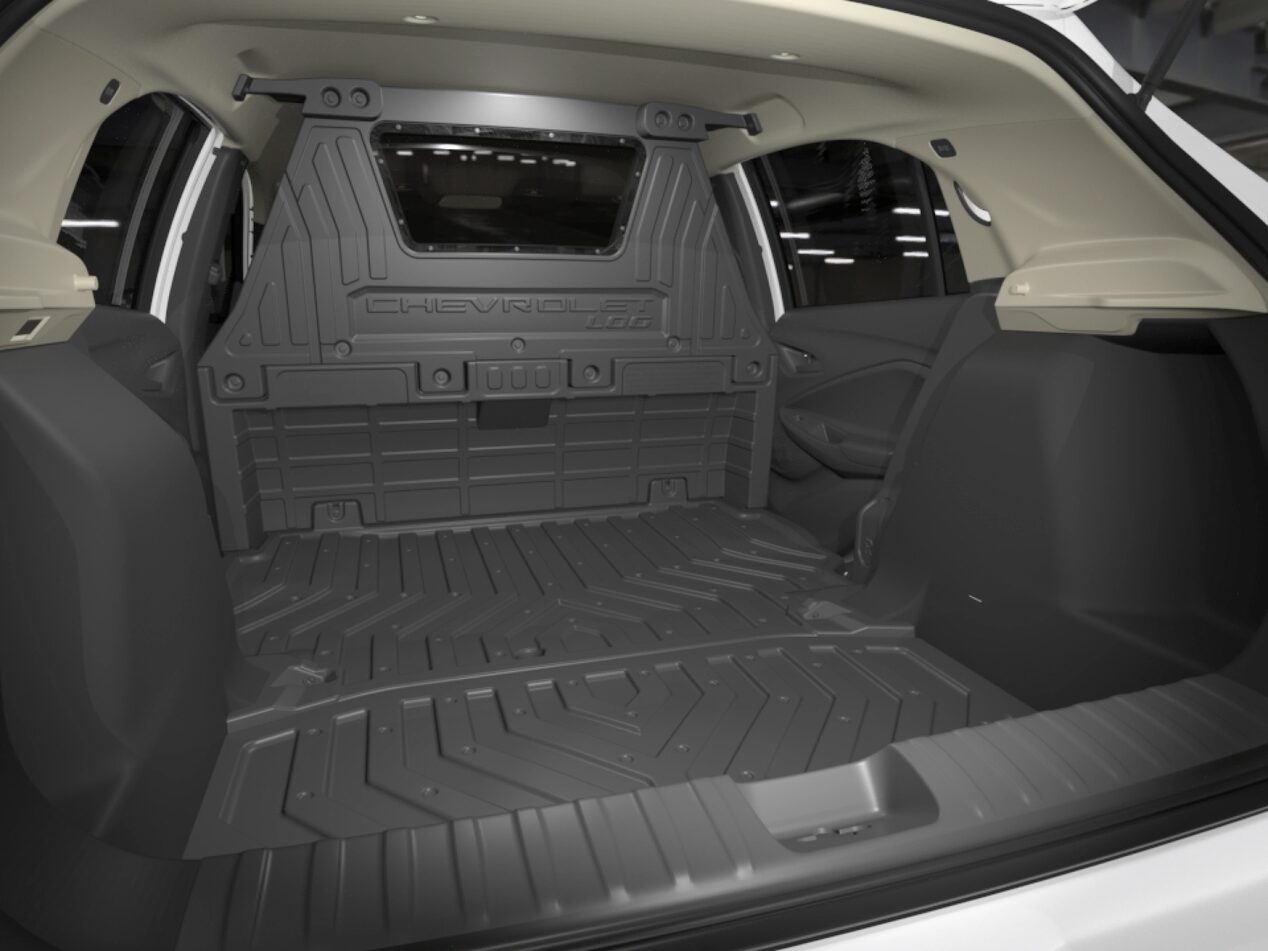 Porta-malas do Onix aberto, destacando amplo espaço interno.