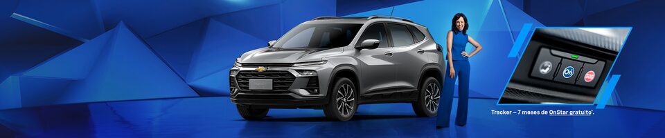 Um Chevrolet Tracker cinza é exibido em frente a um fundo geométrico azul, com uma pessoa vestida de azul ao lado e um encarte mostrando o sistema OnStar. O texto menciona sete meses de OnStar grátis.