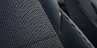 Acabamento do banco Onix na cor preto e cinza e acabamentos em vermelho. 