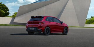 Chevrolet Onix RS Vermelho Scarlet de traseira em ambiente urbano moderno.