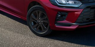 Roda escurecida do Onix RS em destaque, com detalhe da lateral do veículo.