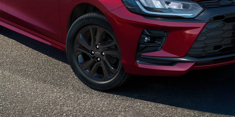 Roda escurecida do Onix RS em destaque, com detalhe da lateral do veículo.