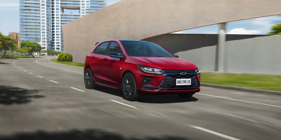 Chevrolet Onix RS Vermelho Scarlet de frente em ambiente urbano.