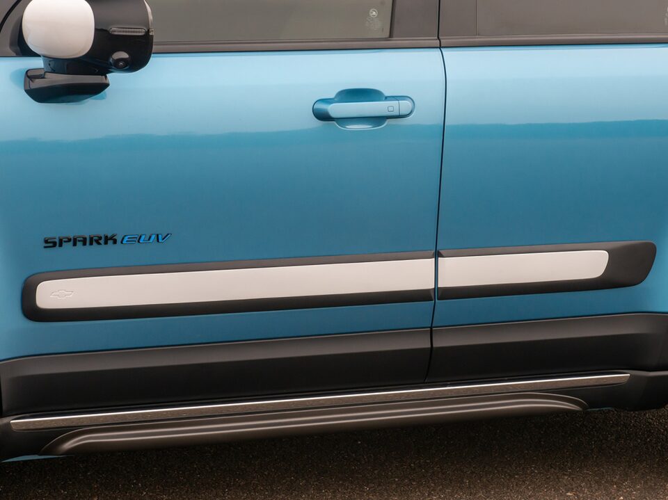 Detalhe do friso de porta na cor branca instalado na lateral do Chevrolet Spark EV, visível entre as duas portas.