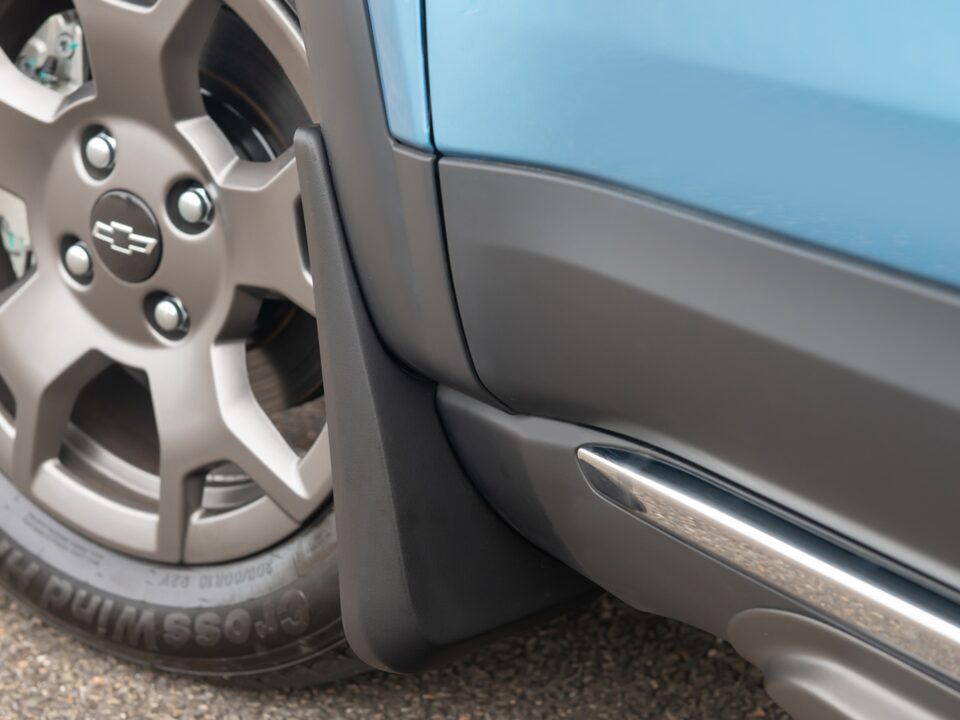 Kit de para-barros instalado atrás da roda dianteira do Chevrolet Spark EUV, em detalhe próximo à caixa de roda e lateral do veículo.
