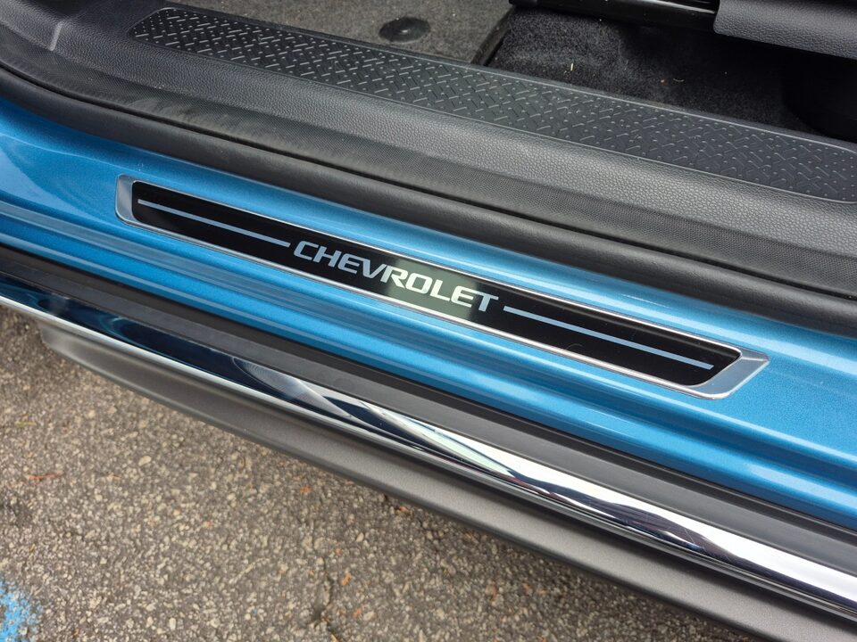  Soleira de porta com acabamento metálico e inscrição “Chevrolet” aplicada na base da entrada do Chevrolet Spark EUV.