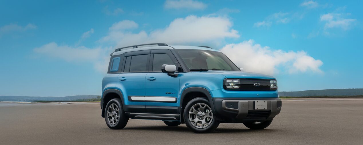 Chevrolet Spark EUV na cor Azul Atlântico em vista de frente e lateral direita, estacionado em pista aberta sob céu azul com nuvens