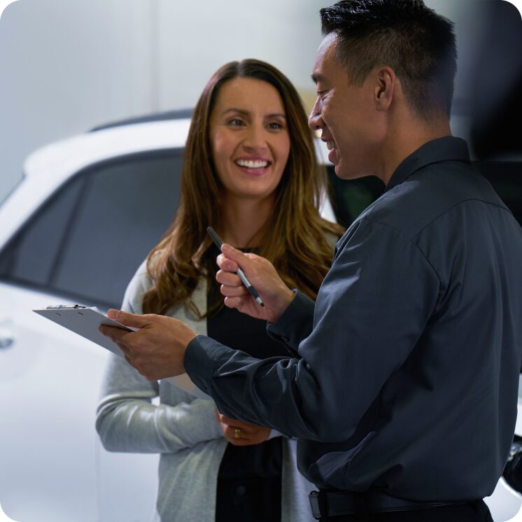 Mulher falando com homem de concessionária