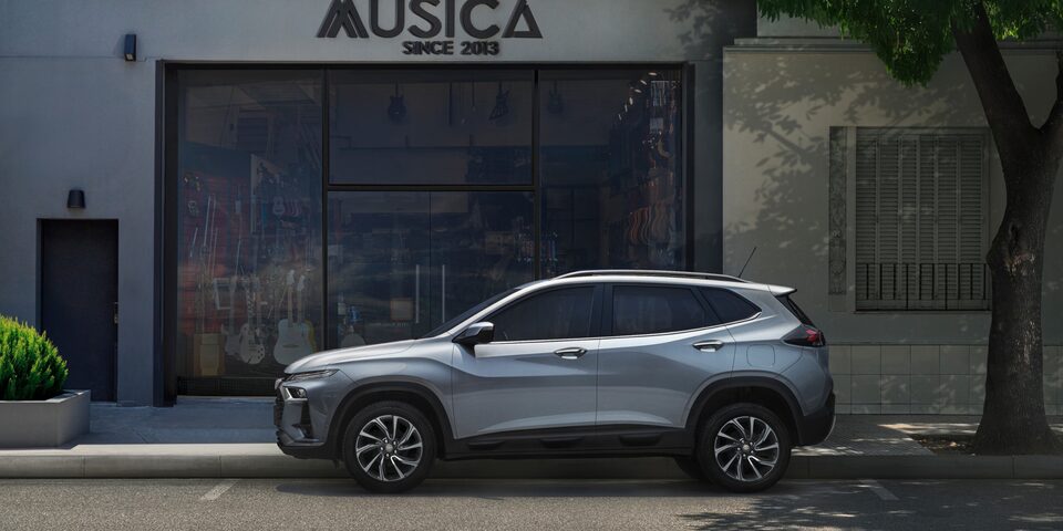 Vista lateral de la Chevrolet Tracker color Gris Plata Tiburón estacionada en zona urbana.