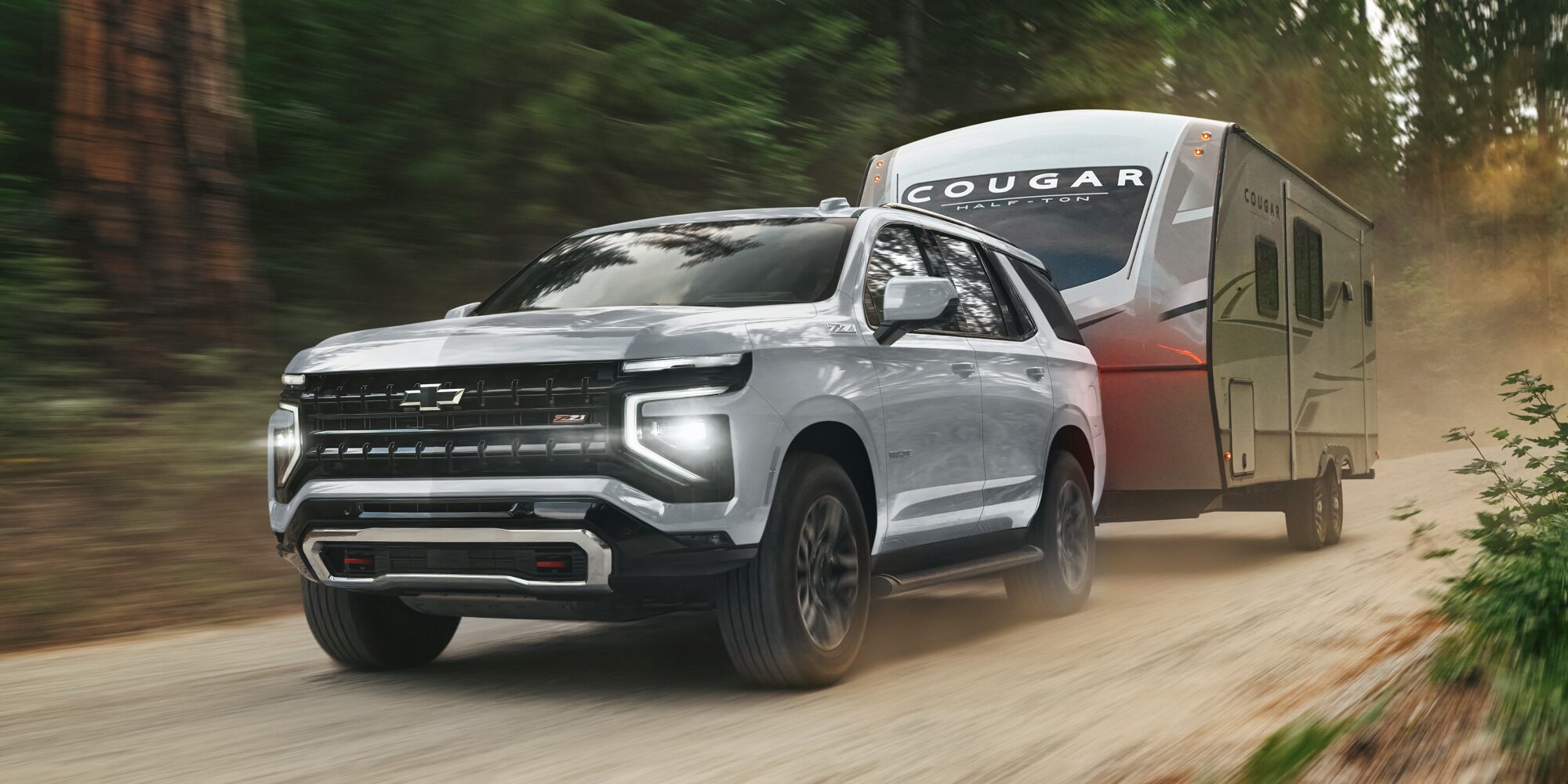 Chevrolet Tahoe transportando un tráiler por un camino de tierra.