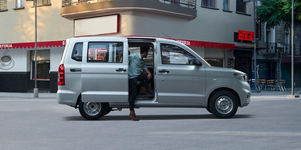 Vista lateral de Van Chevrolet gris con hombre ingresando.