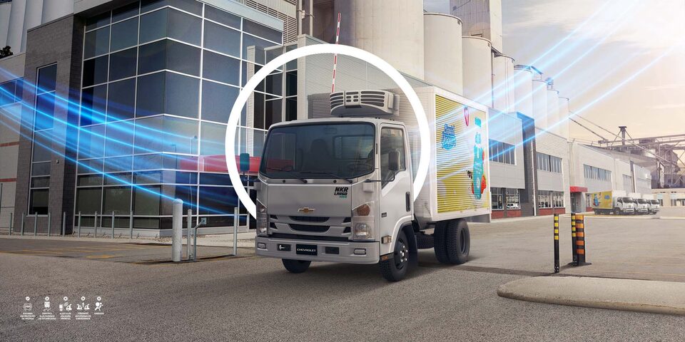 Camión Chevrolet de carga refrigerada estacionado en un complejo industrial, resaltando soluciones de transporte inteligente.