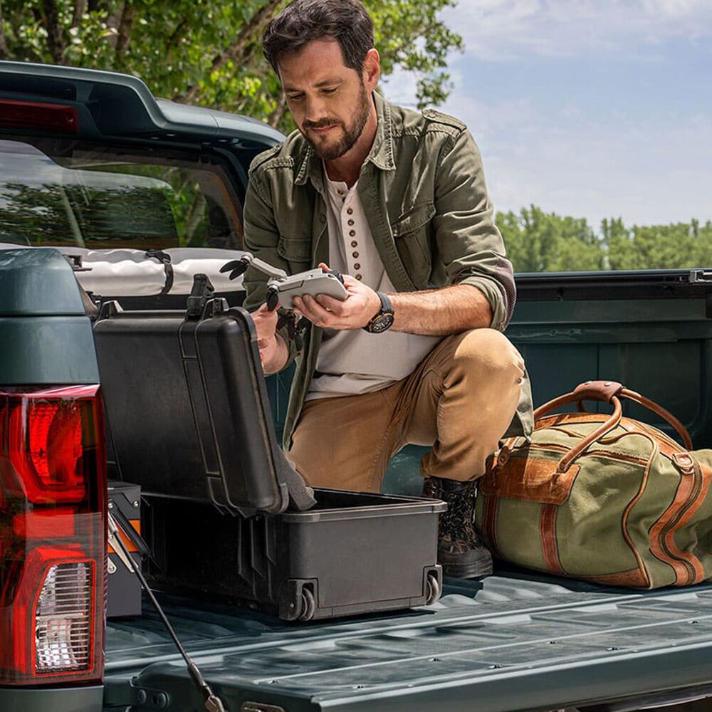 Hombre cargando herramientas en la caja de la Chevrolet Colorado.
