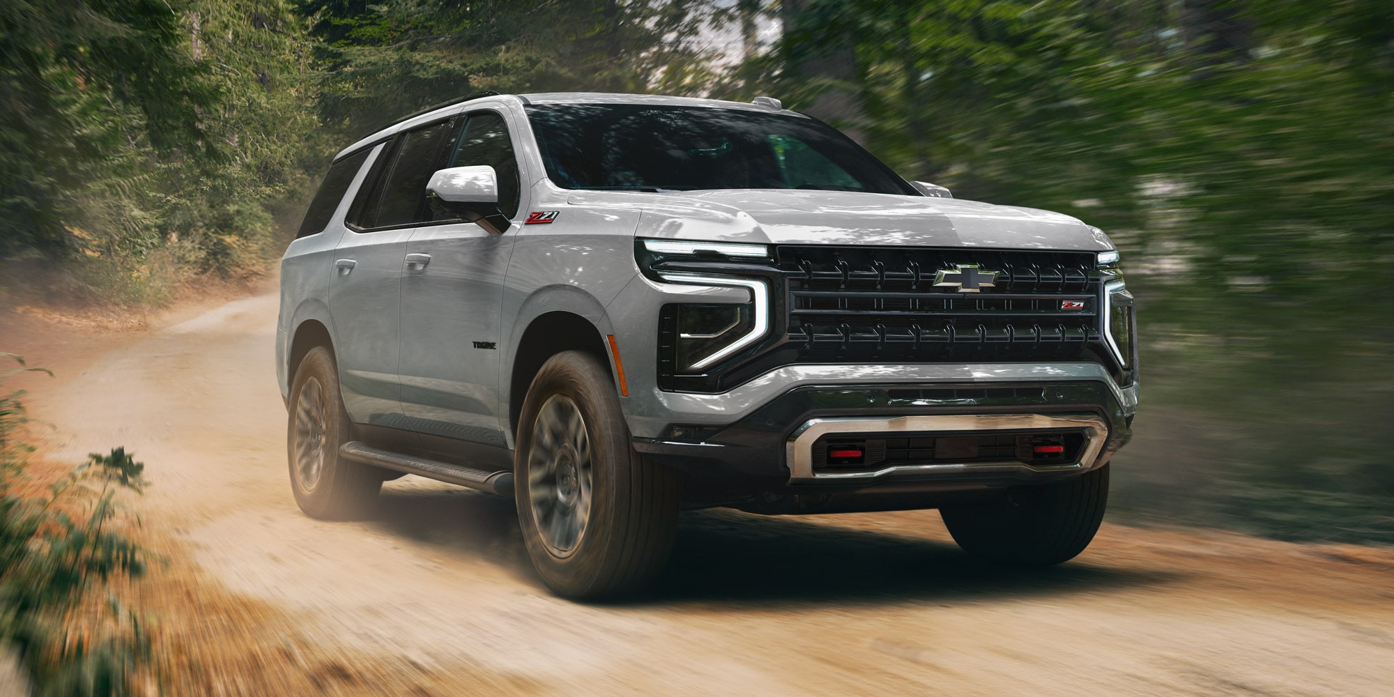 Chevrolet Tahoe andando a toda velocidad por un sendero en el bosque.