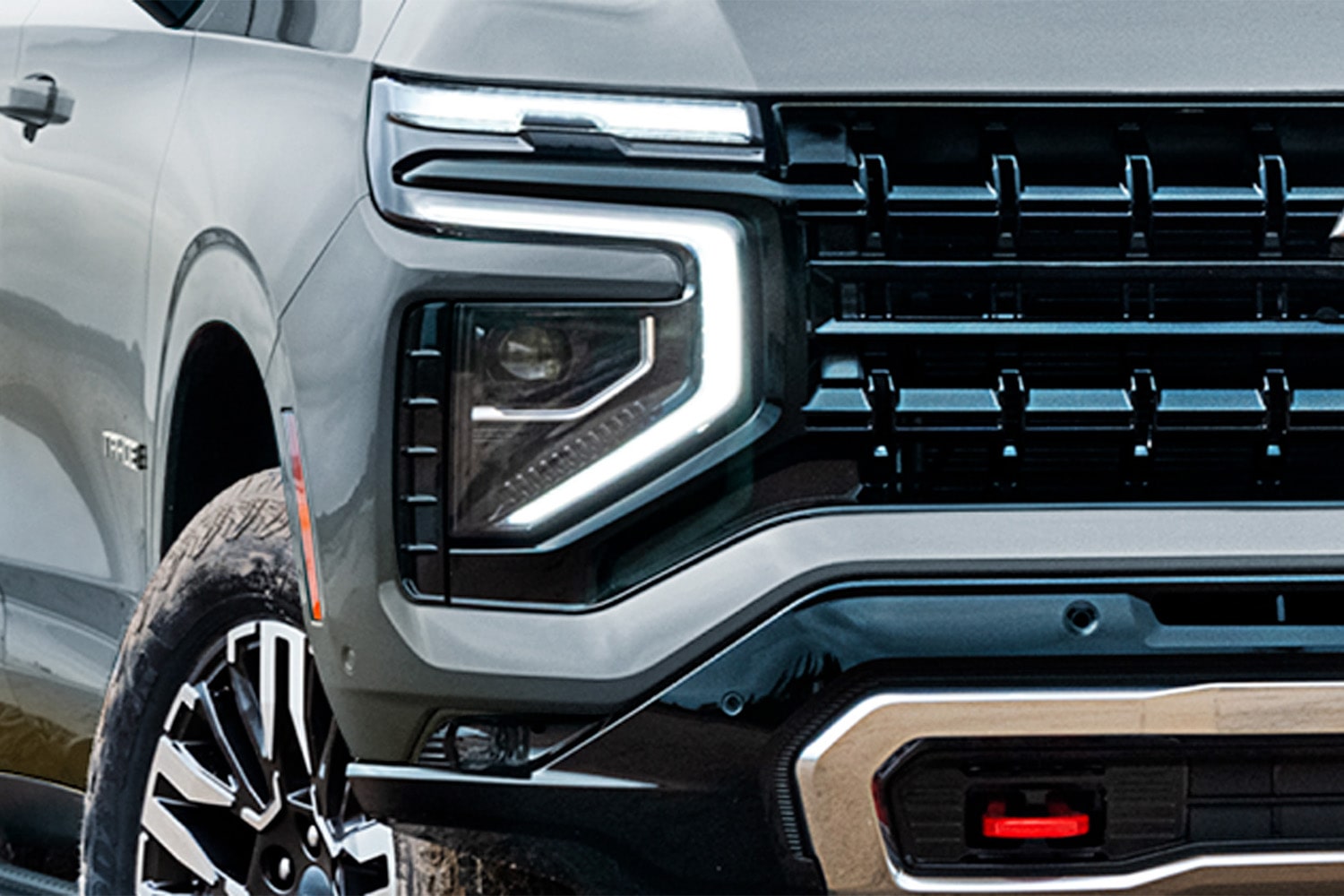 Imagen en detalle del capó de la Chevrolet Tahoe, enfocado en el faro delantero derecho.