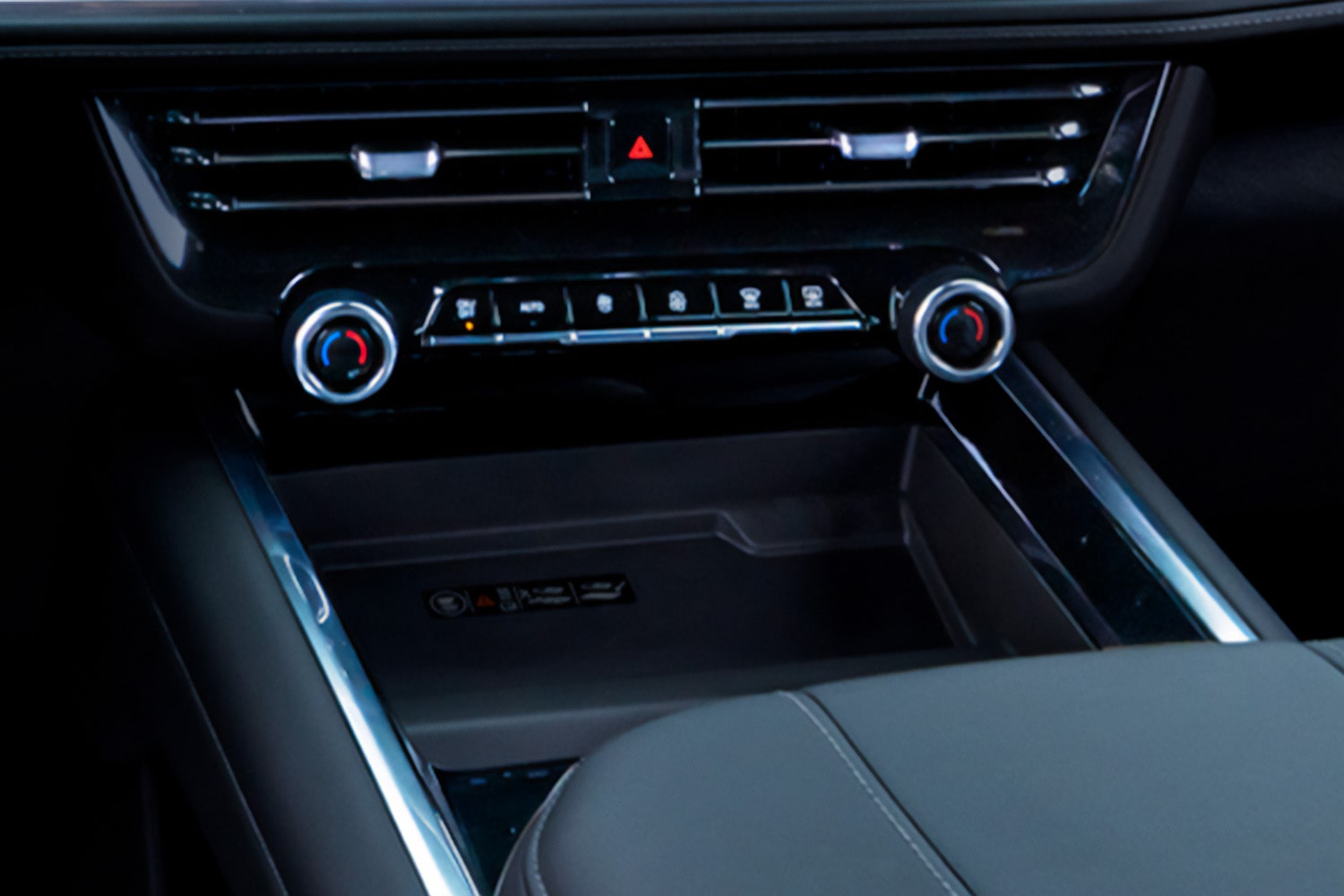 Vista en detalle de la salida de aira central y los controles de ajuste de la Chevrolet Tahoe, así también como el cargador de celular inalámbrico.