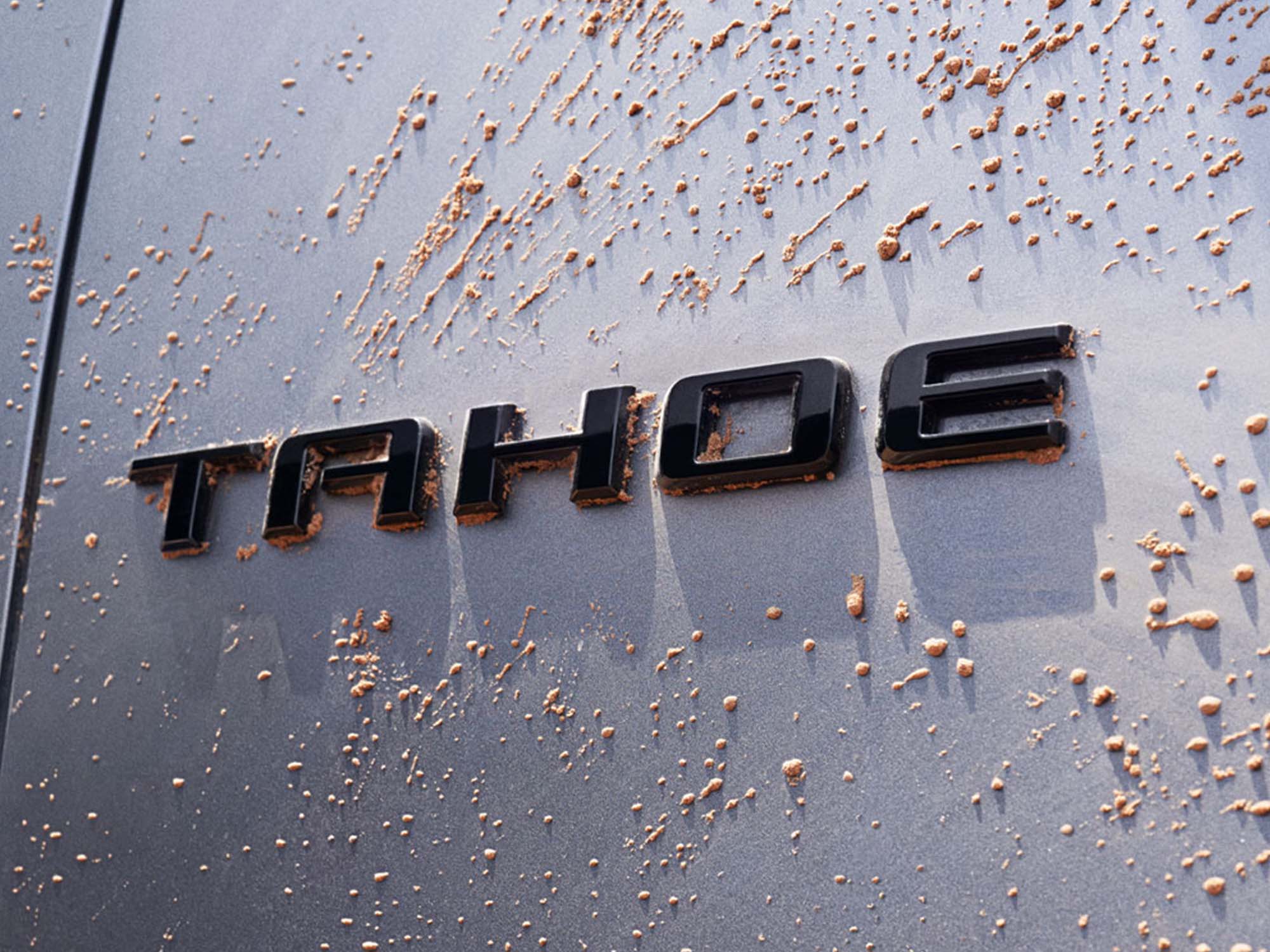 Primer plano de la insignia Tahoe rodeada de gotas de barro secas.