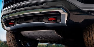 Vista en primer plano de la parte trasera inferior de una Chevrolet Tahoe, mostrando el paragolpes, la protección metálica inferior y detalles del chasis.