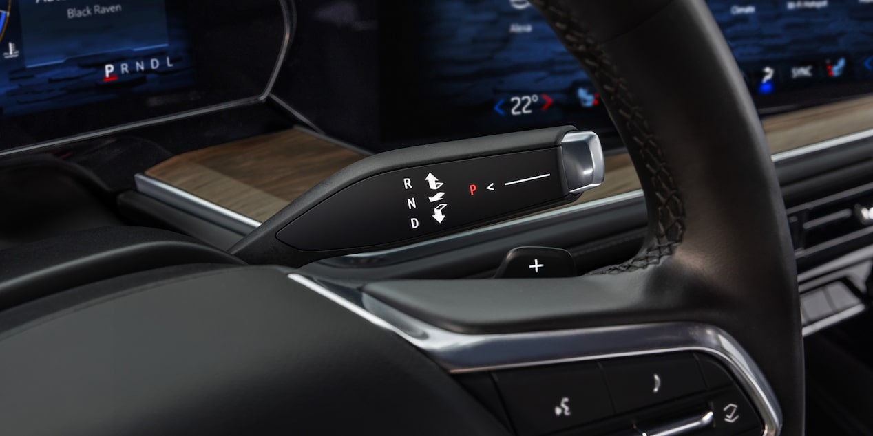 Detalle de la palanca de cambios electrónica detrás del volante de una Chevrolet Tahoe.