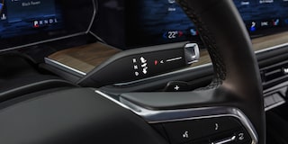 Detalle de la palanca de cambios electrónica detrás del volante de una Chevrolet Tahoe.