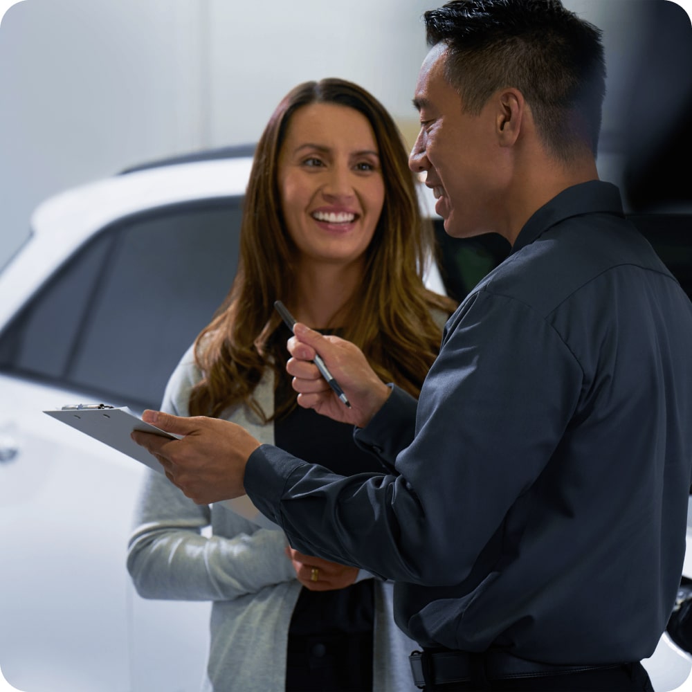 Imagen de una mujer siendo asesorada por una vendedor de una concesionaria Chevrolet.