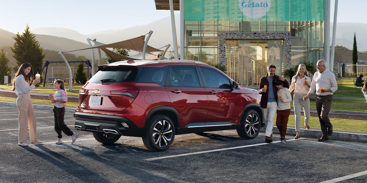 Chevrolet Captiva XL estacionada con una familia rodeándola.