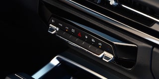 Controles del aire acondicionado digital de la Chevrolet Groove, con botones táctiles y detalles cromados ubicados bajo la pantalla central del sistema de infoentretenimiento.