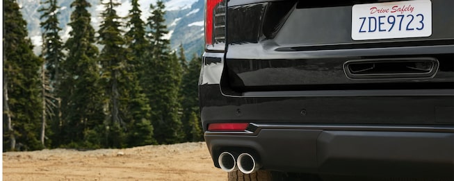 Vista trasera de Chevrolet Tahoe con doble escape en un entorno natural de montaña, destacando diseño deportivo y espíritu aventurero SUV