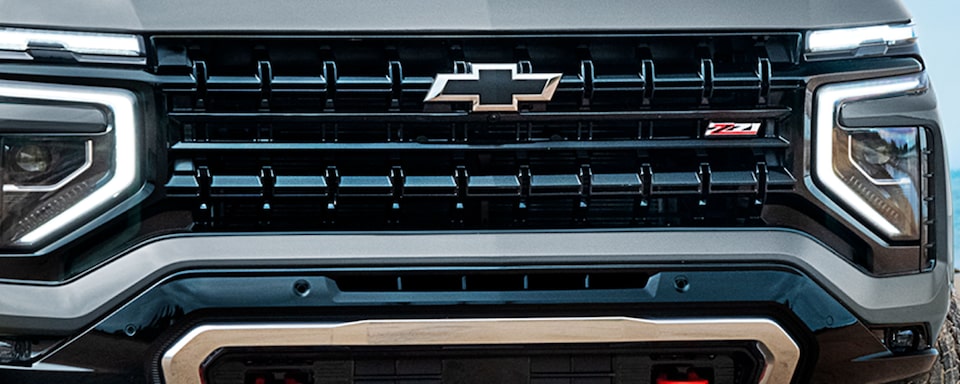 Detalle de parrilla frontal de Chevrolet Tahoe con logo Chevrolet iluminado y diseño robusto
