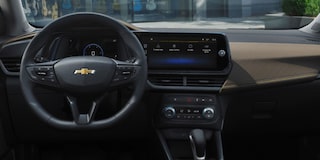 Vista interior de la Chevrolet Silverado, mostrando volante, pantalla digital táctil, controles del aire acondicionado, guantera y más.