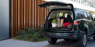 Chevrolet Trailblazer estacionada con el maletero abierto con maletas adentro.