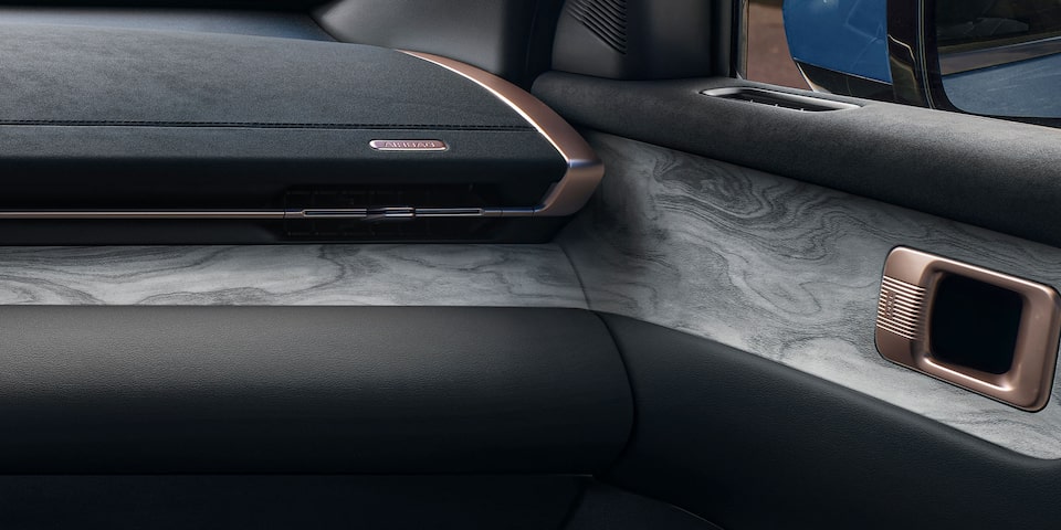 Vista en detalle de del panel interior de la Chevrolet Captiva PHEV con acabado simil madera y manija metálica.