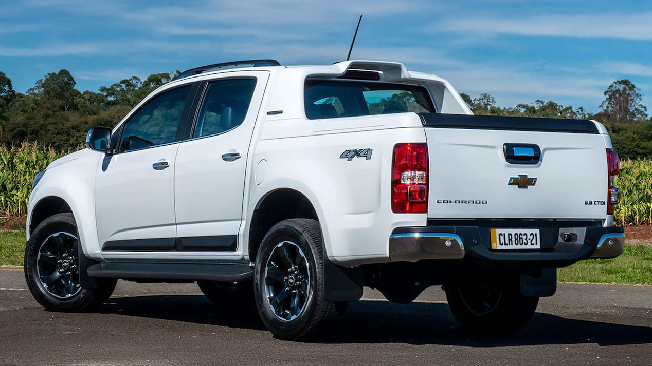 Vista trasera de la Chevrolet Colorado estacionada con vegetación de fondo.