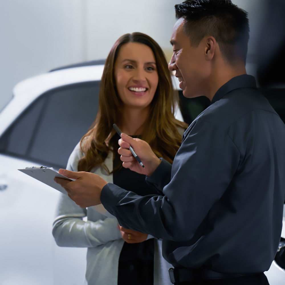 Asesor de servicio atendiendo a una clienta en un concesionario Chevrolet.