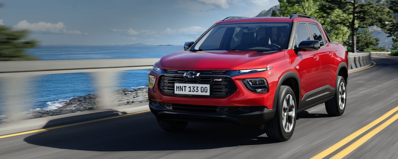 Chevrolet Montana circulando por una carretera con un cuerpo de agua de fondo.