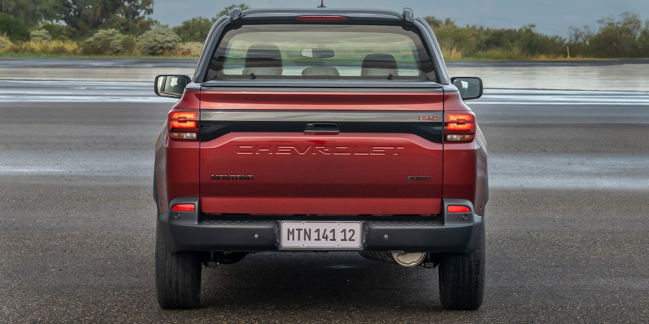 Vista lateral de una Montana Roja estacionada enfocando en el emblema de Chevrolet.