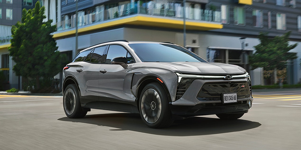 Chevrolet Blazer EV circulando por una calle, con edificios y árboles de fondo.