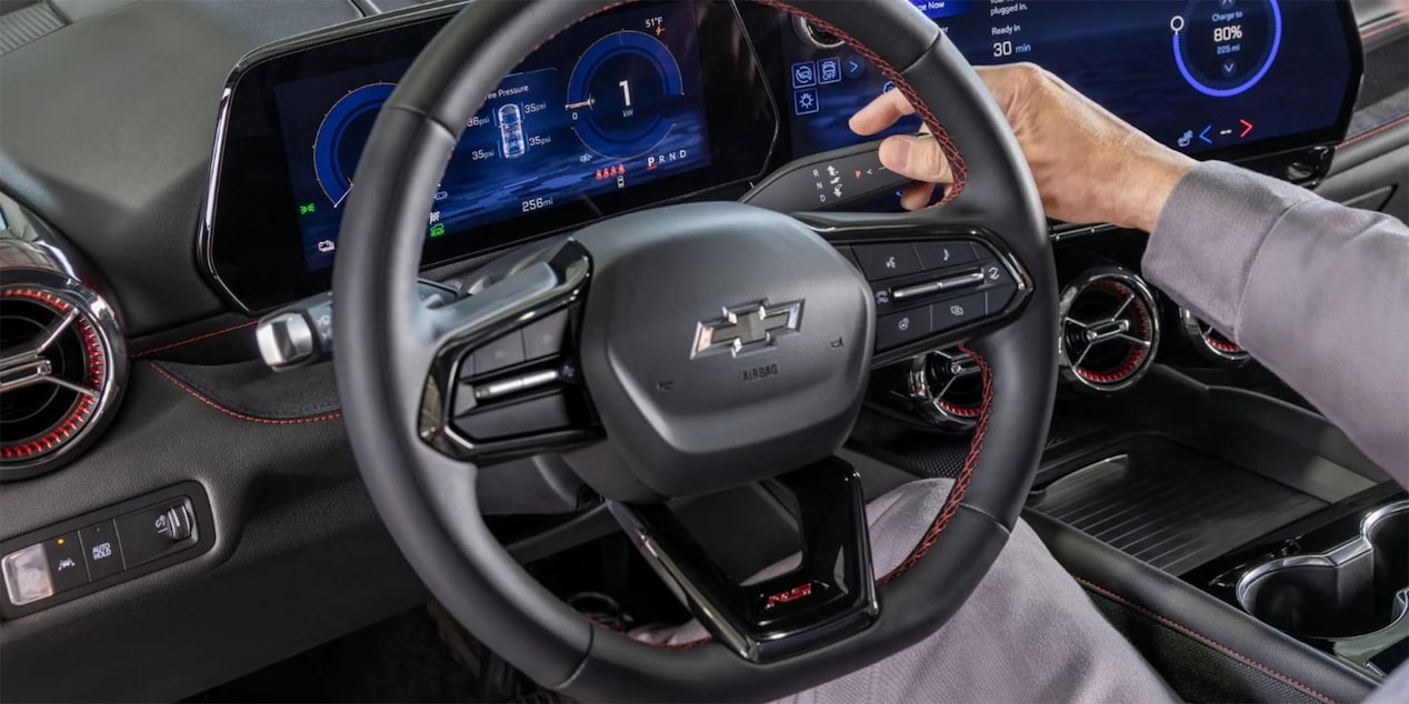 Imagen en detalle del volante de la Chevrolet Blazer EV, mientras la mano del conductor activa uno de sus botones.