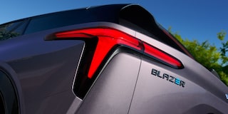 Imagen en detalle del faro trasero izquierdo junto a la insignia Blazer con la letra E en color azul.